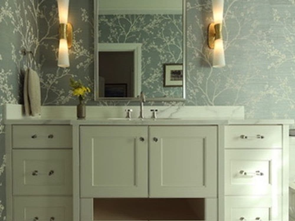 Modern bathroom with floral wallpaper, double sink vanity, and stylish wall sconces.