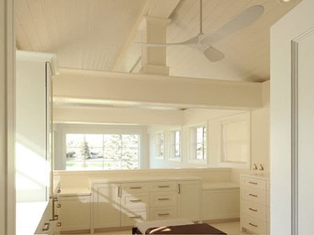 Bright, spacious modern interior with white cabinetry and ceiling fan for a stylish look.