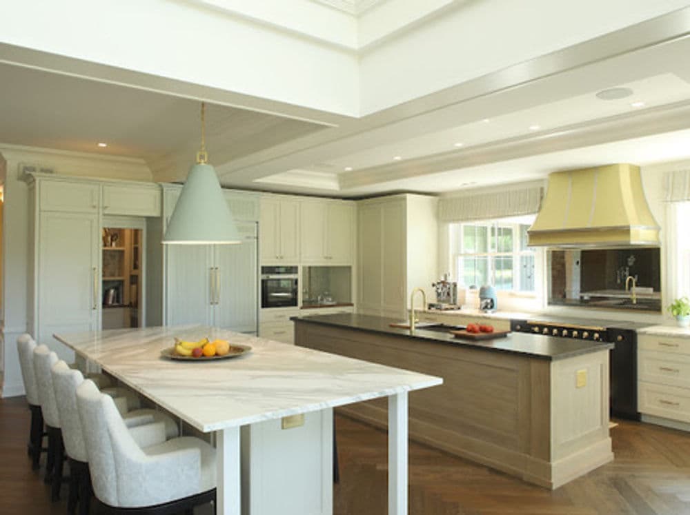 Modern kitchen with marble island, light fixtures, and stylish cabinetry in bright interior design.