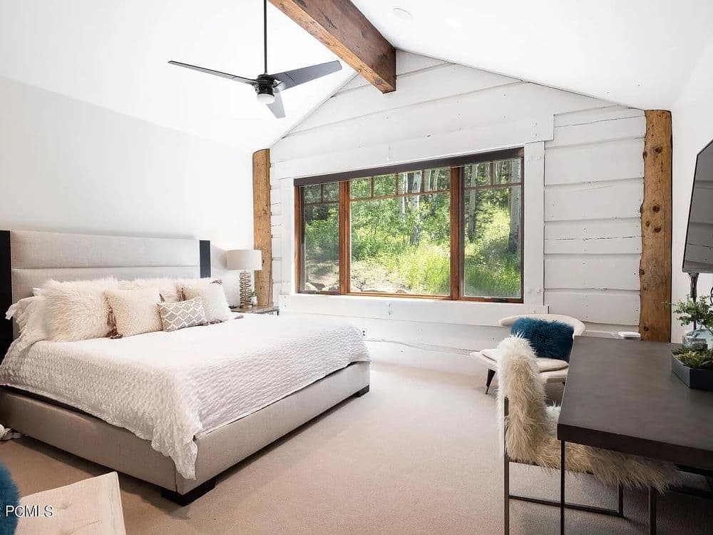 Cozy modern bedroom with natural light, wooden accents, and stylish decor.
