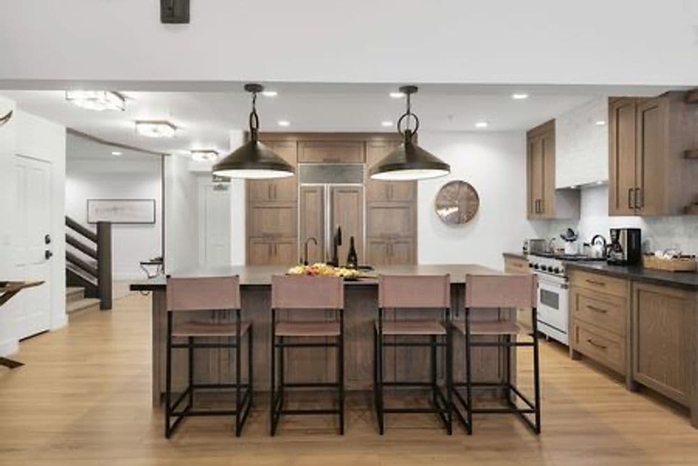Modern kitchen with wooden cabinets, large island, and stylish barstools for entertaining.