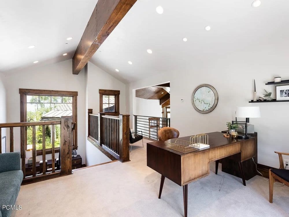 Modern home office with wooden beams, stylish desk, and natural light. Cozy and inviting space.
