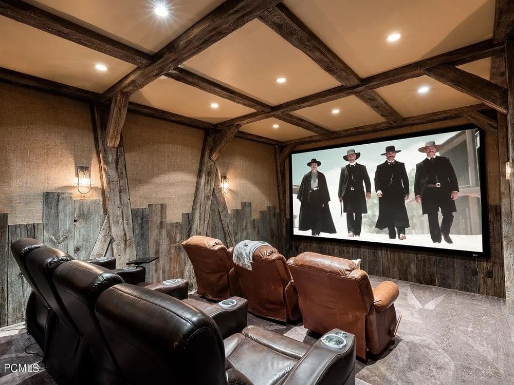 Home theater with leather recliners, wooden beams, and a large screen showing a Western film.