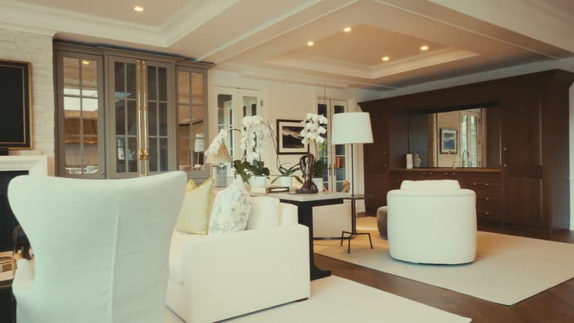 Modern living room with white chairs, stylish decor, and elegant lighting accents.